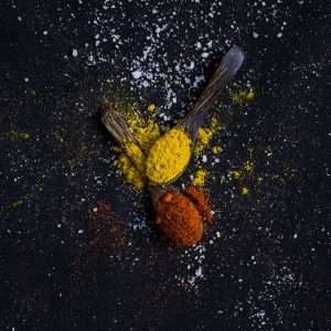 Red and yellow spice on spoons