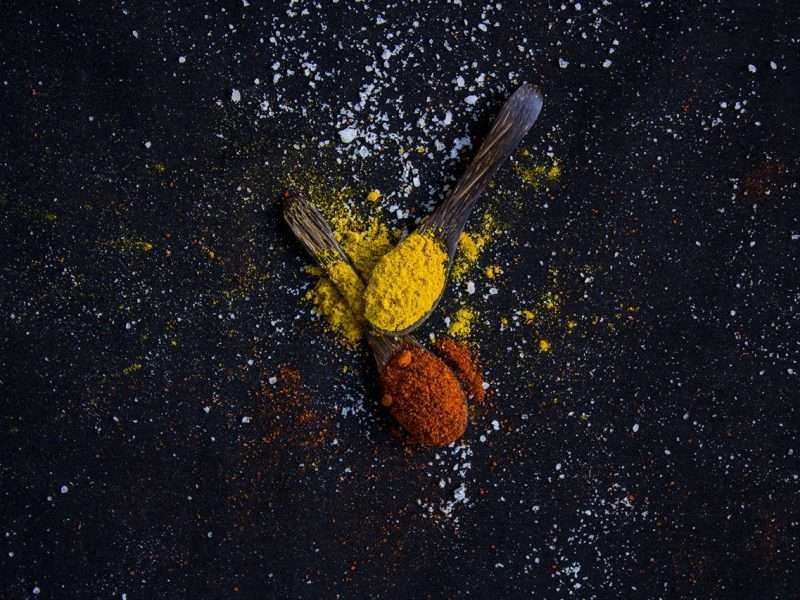 Red and yellow spice on spoons
